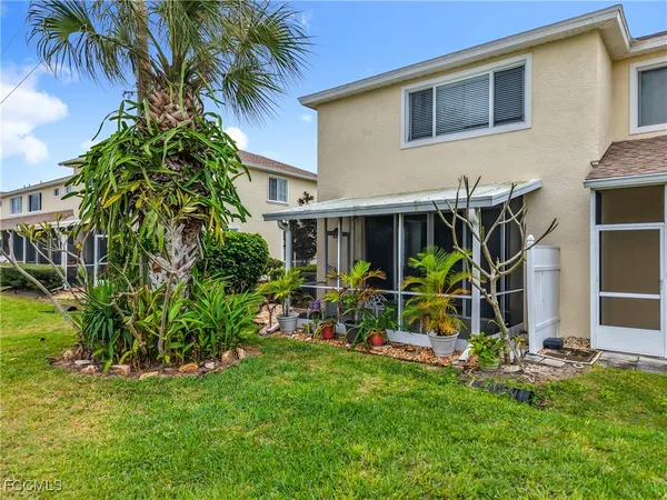 a palm tree sitting in front of a house with a yard