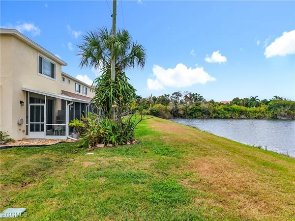 a view of a big house with a big yard and potted plants