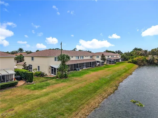 a view of a large pool with a big yard and large trees