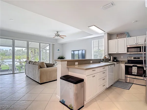 a kitchen with stainless steel appliances granite countertop grey cabinets a stove a sink and dishwasher