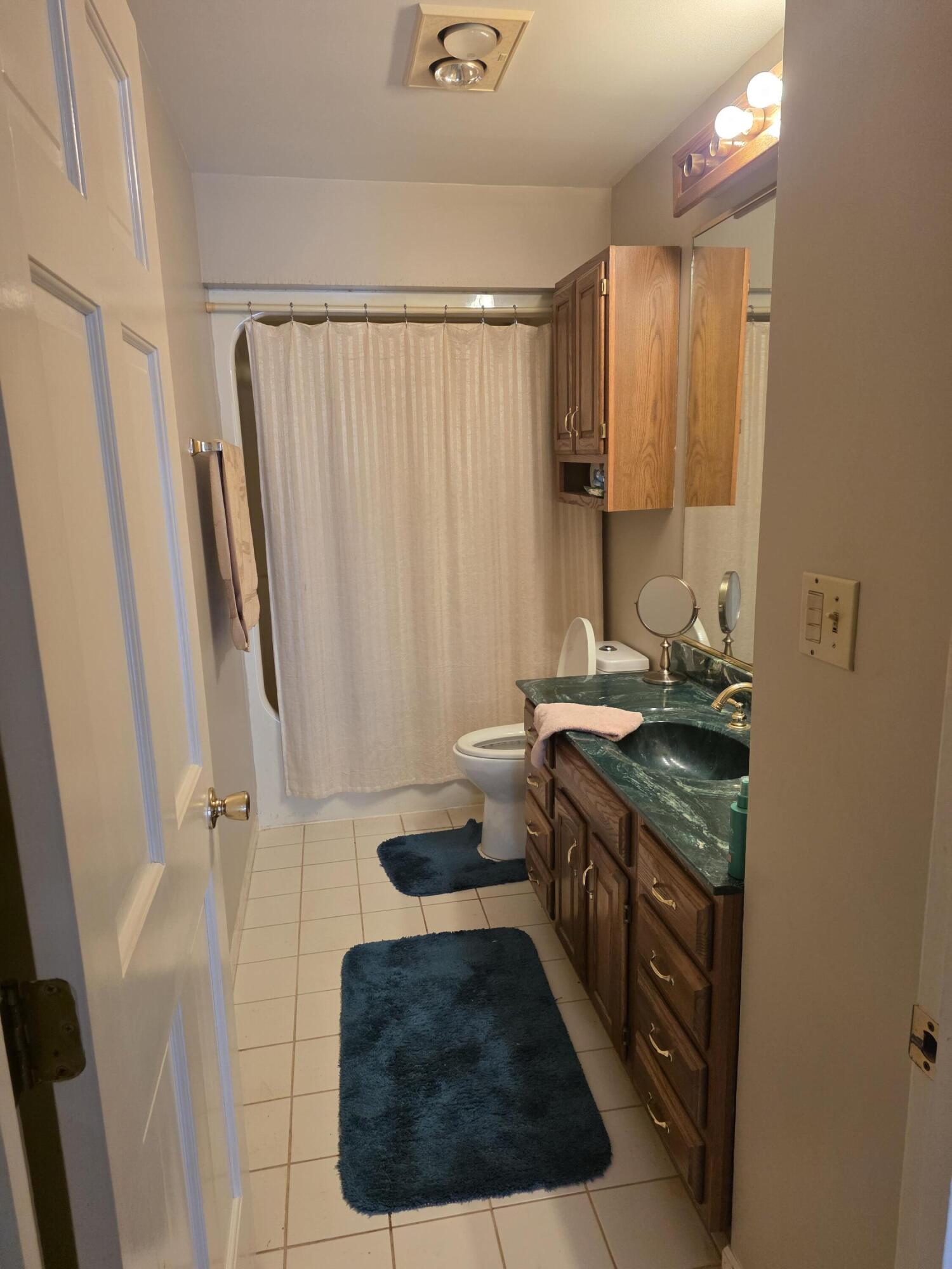 516 Begonia Street Southeast, Unit A De Motte, IN 46310 - Photo 23 of 25 a bathroom with a granite countertop sink a toilet a mirror and shower
