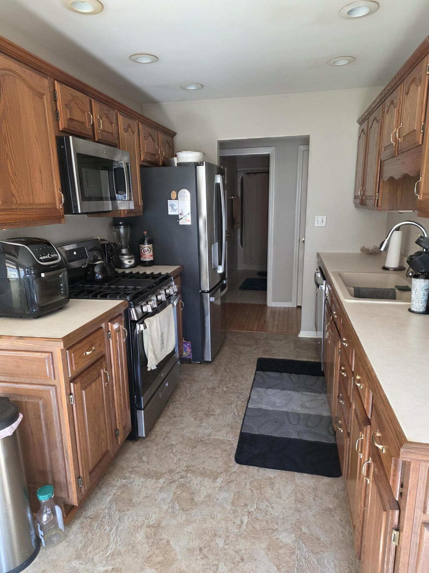 516 Begonia Street Southeast, Unit A De Motte, IN 46310 - Photo 8 of 25 a kitchen with stainless steel appliances granite countertop a stove a sink and a microwave