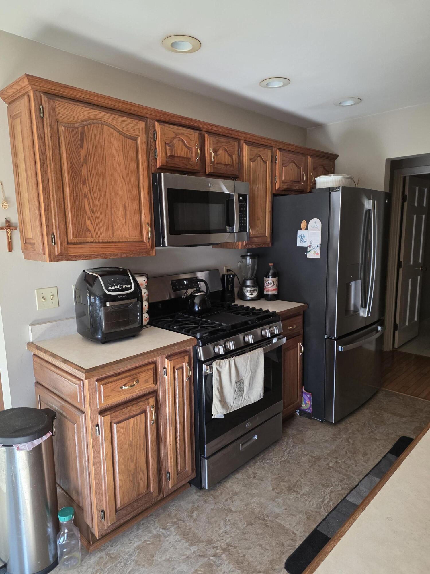 516 Begonia Street Southeast, Unit A De Motte, IN 46310 - Photo 9 of 25 a kitchen with stainless steel appliances granite countertop a stove a sink and a microwave