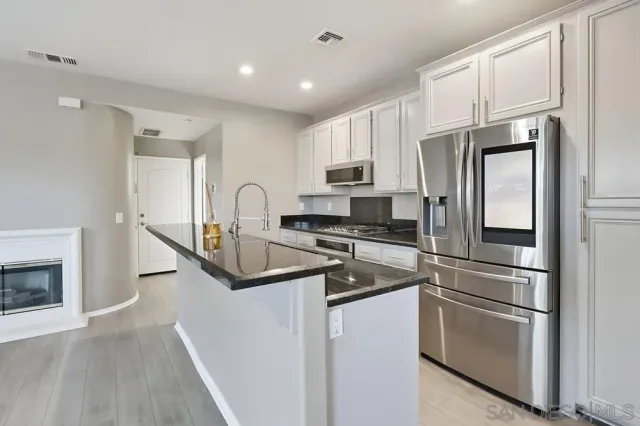 a kitchen with stainless steel appliances granite countertop a refrigerator sink and stove