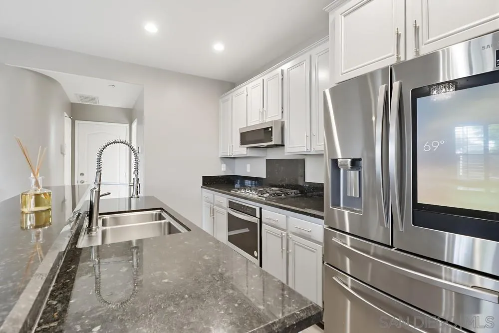 2170 Bobcat Court, Unit 126 Chula Vista, CA 91915 - Photo 8 of 28 a kitchen with granite countertop a refrigerator and a sink