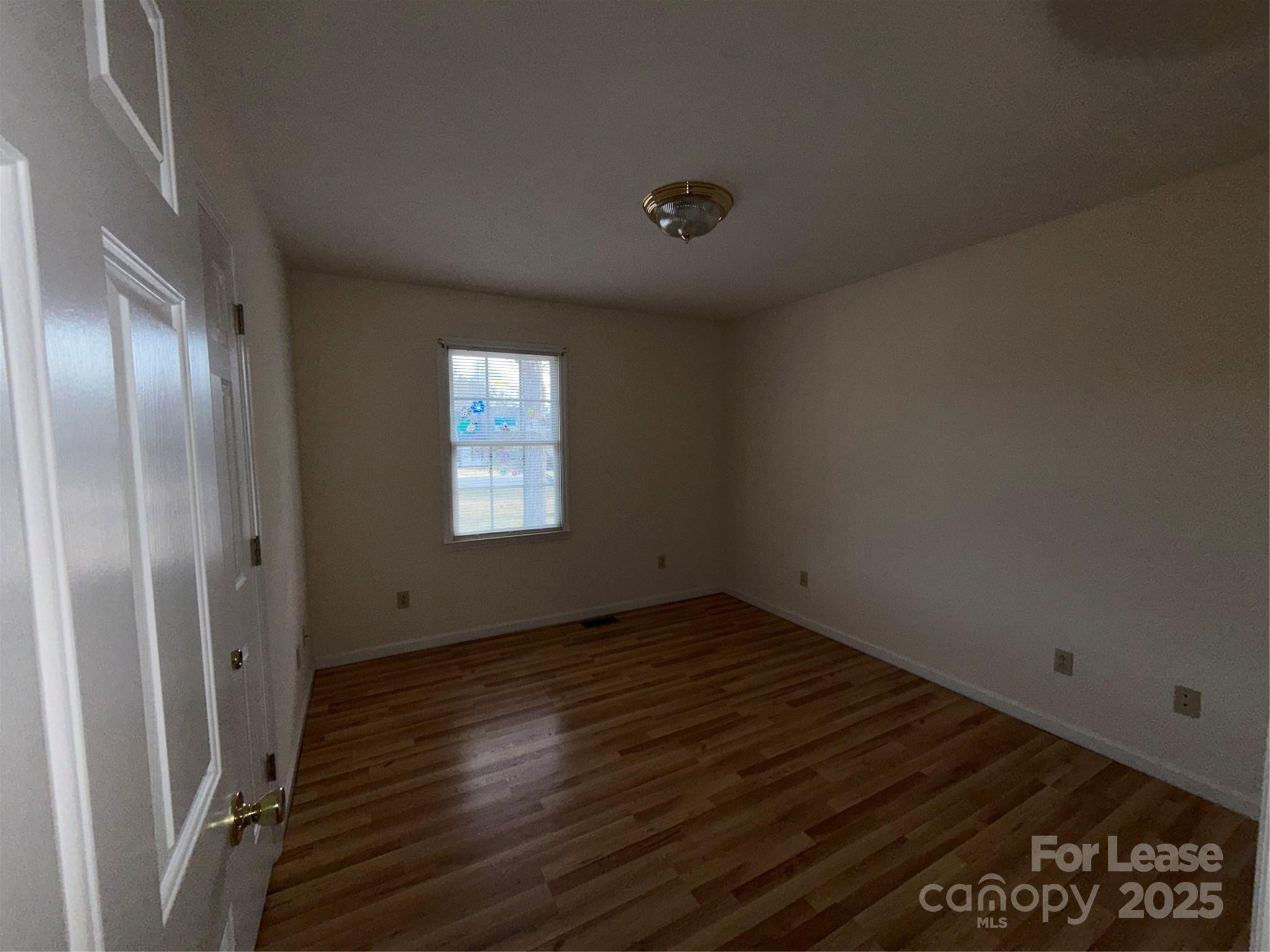 401 Miller Farm Road Statesville, NC 28625 - Photo 8 of 18 a view of an empty room with wooden floor and a window