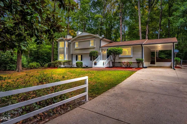 a view of an house with backyard and a tree