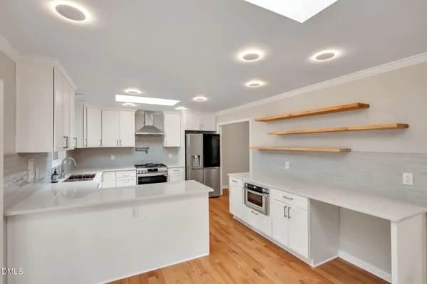a kitchen that has a lot of cabinets in it and wooden floors