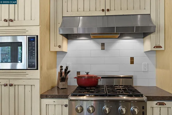 a stove top oven sitting inside of a kitchen