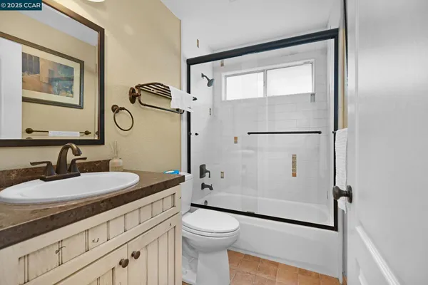 a bathroom with a granite countertop sink toilet and shower