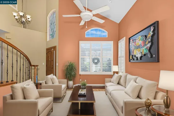 a living room with furniture a chandelier and a large window
