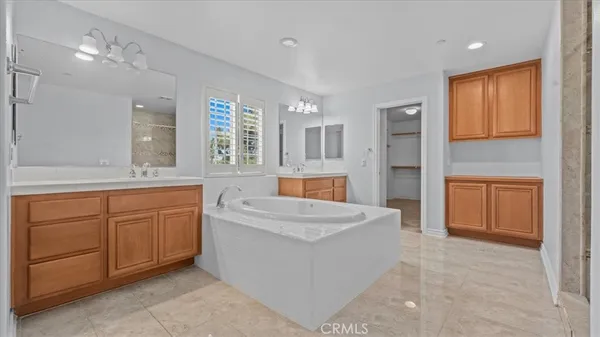 a spacious bathroom with a granite countertop sink mirror and bathtub