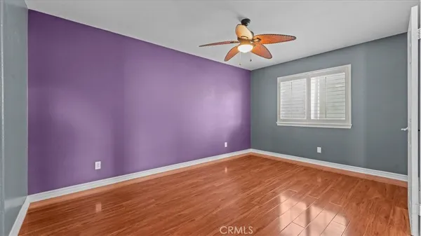 a view of a big room with wooden floor and windows