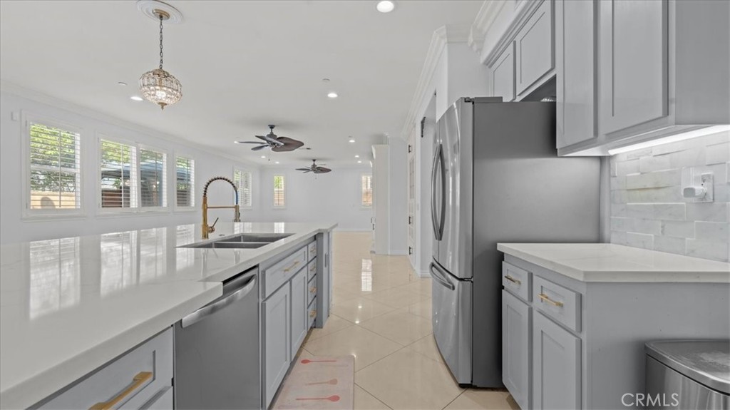 5448 Turin Way Fontana, CA 92336 - Photo 10 of 40 a kitchen with a sink stainless steel appliances a counter top space cabinets and a chandelier
