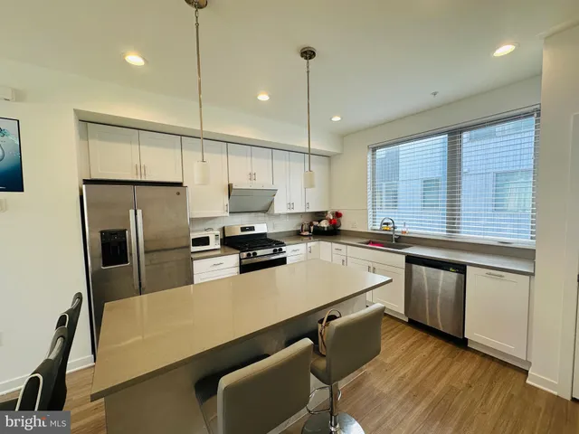 a kitchen with refrigerator cabinets and wooden floor