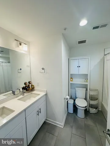 a bathroom with a double vanity sink toilet and a mirror