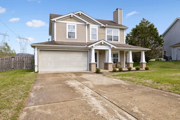 a front view of a house with a garden and garage
