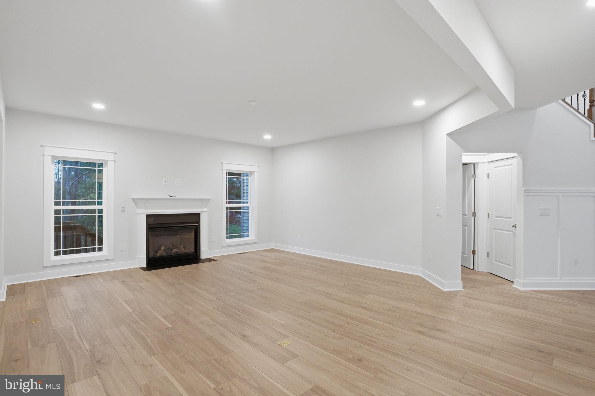 25015 Prairie Lane, Unit 3 Millsboro, DE 19966 - Photo 12 of 42 an empty room with wooden floor fireplace and windows