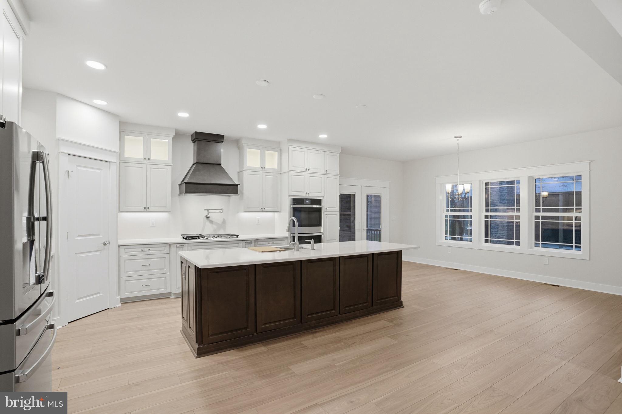 25015 Prairie Lane, Unit 3 Millsboro, DE 19966 - Photo 13 of 42 a kitchen with kitchen island a sink stainless steel appliances and cabinets