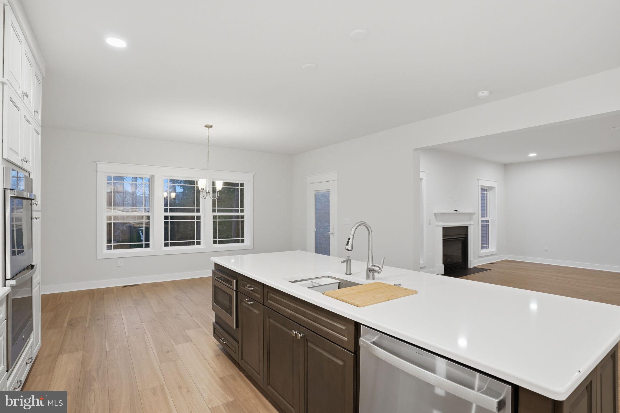25015 Prairie Lane, Unit 3 Millsboro, DE 19966 - Photo 18 of 42 a kitchen with a sink dishwasher and a stove with wooden floor