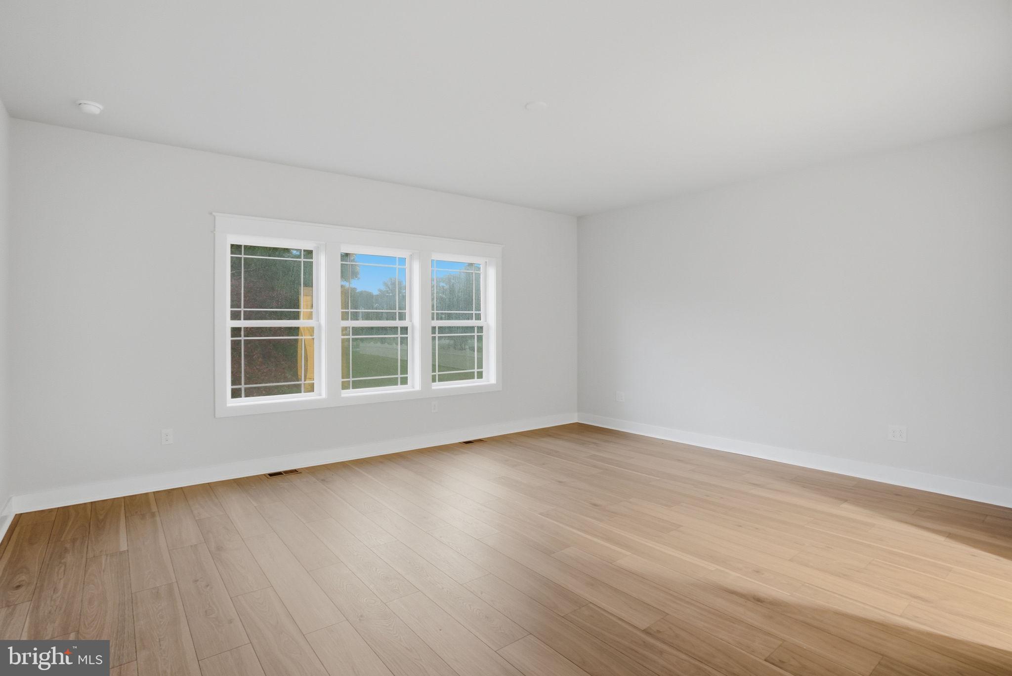 25015 Prairie Lane, Unit 3 Millsboro, DE 19966 - Photo 23 of 42 a view of an empty room with wooden floor and a window
