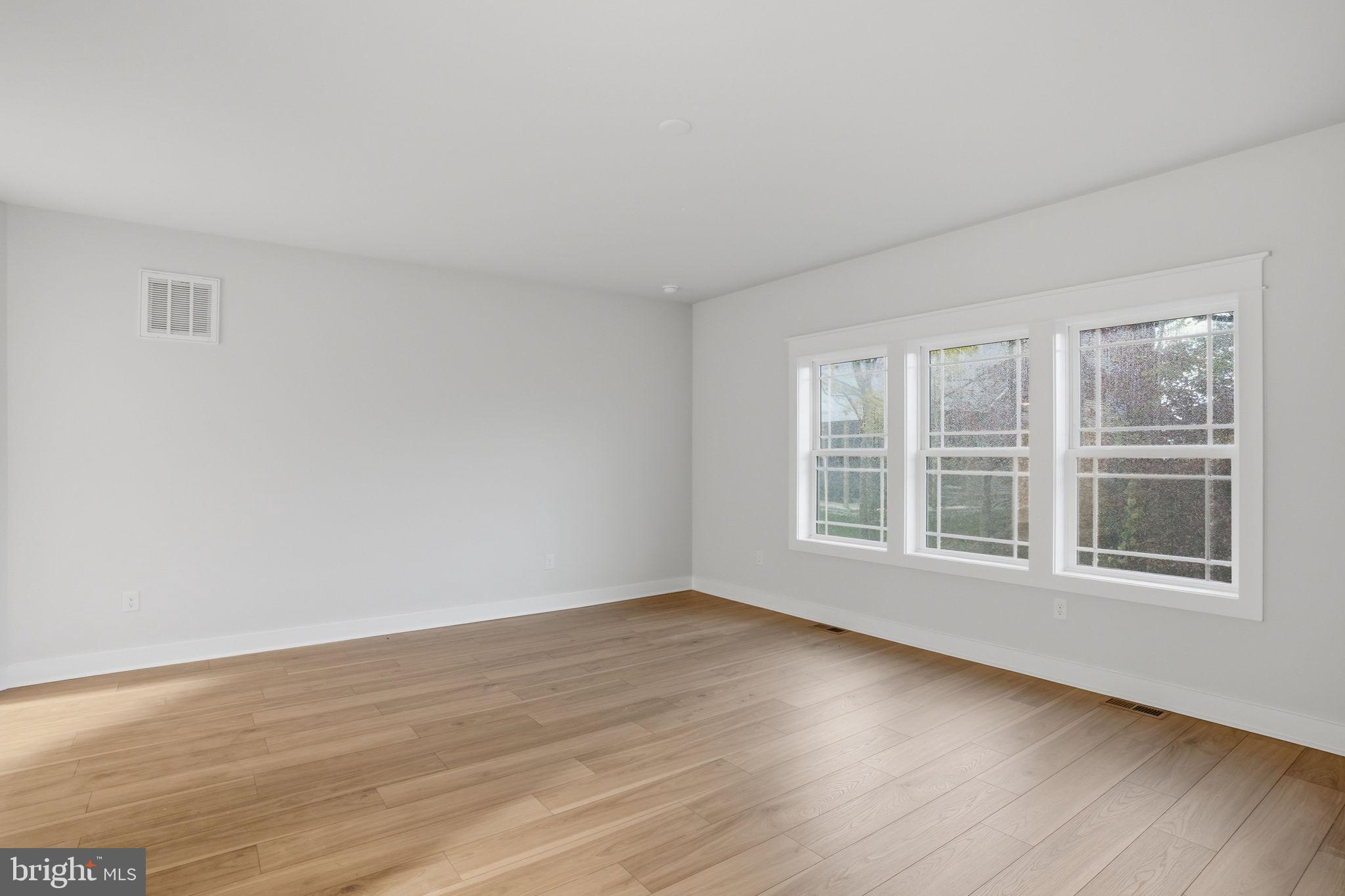 25015 Prairie Lane, Unit 3 Millsboro, DE 19966 - Photo 25 of 42 a view of an empty room with wooden floor and a window