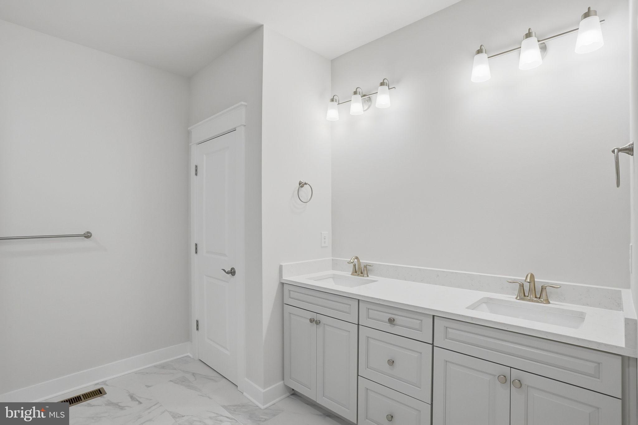 25015 Prairie Lane, Unit 3 Millsboro, DE 19966 - Photo 26 of 42 a bathroom with a double vanity sink a mirror and a shower