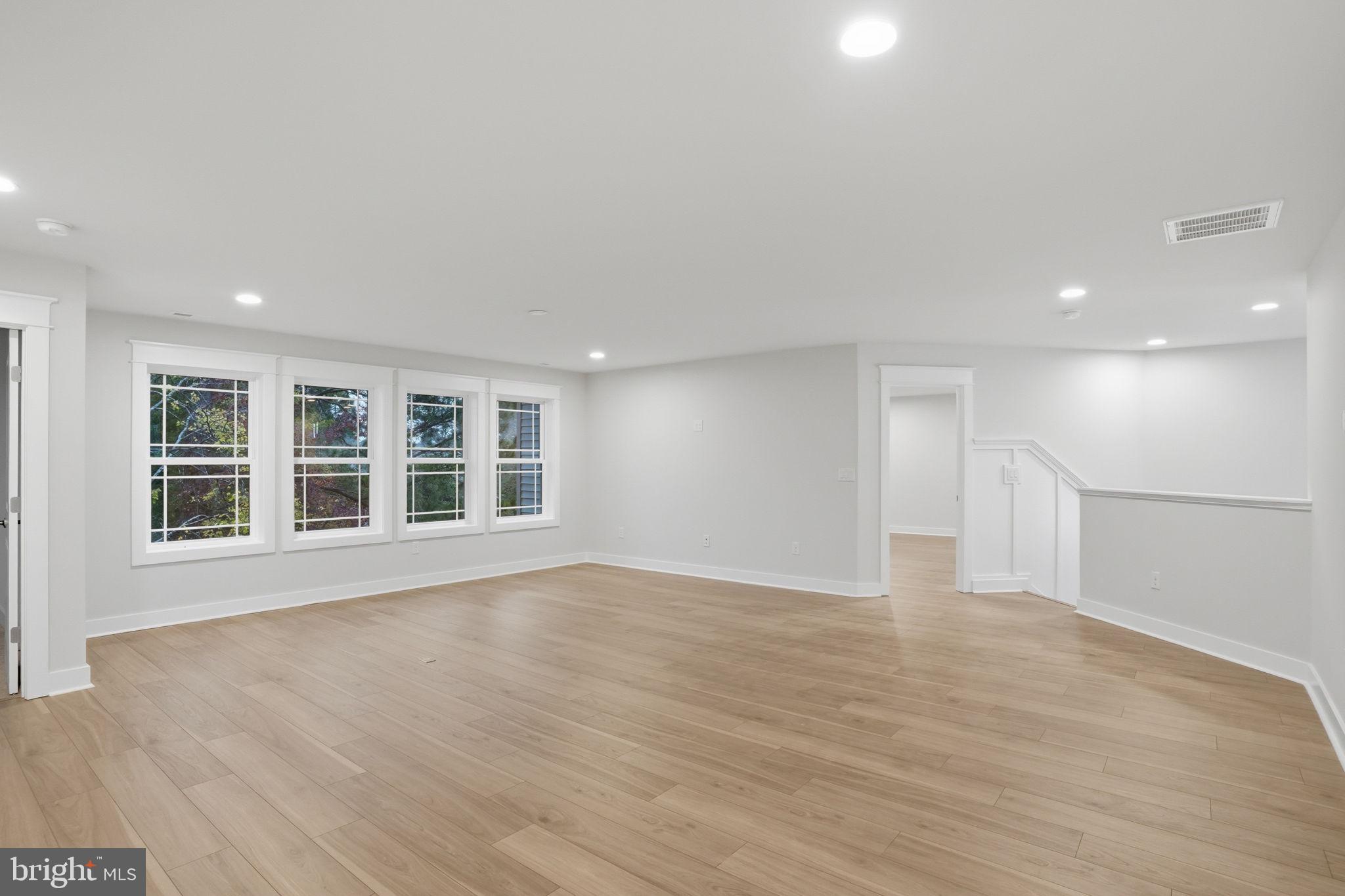 25015 Prairie Lane, Unit 3 Millsboro, DE 19966 - Photo 29 of 42 a view of an empty room with wooden floor and windows