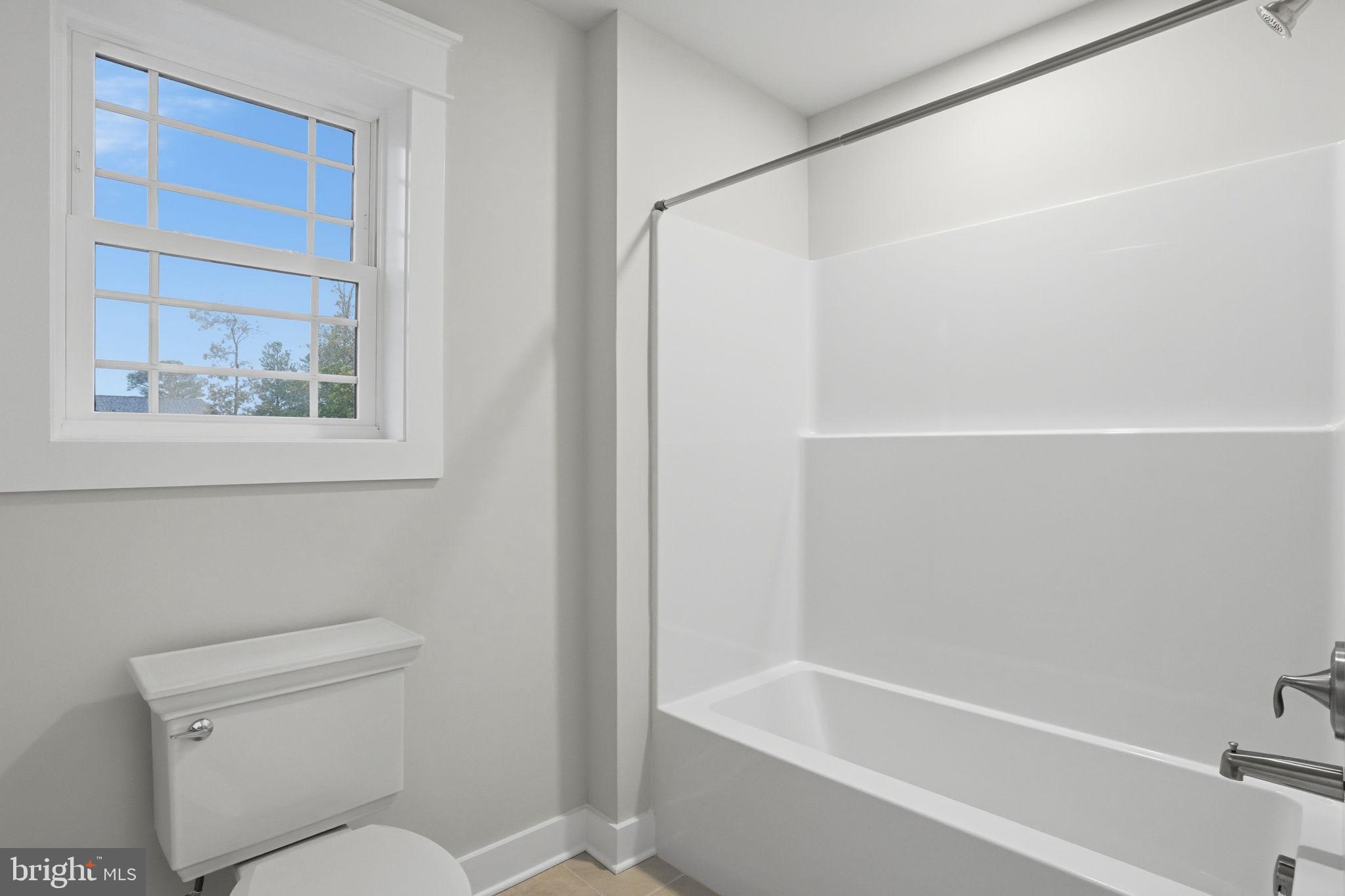 25015 Prairie Lane, Unit 3 Millsboro, DE 19966 - Photo 33 of 42 a white toilet sitting next to a bath tub
