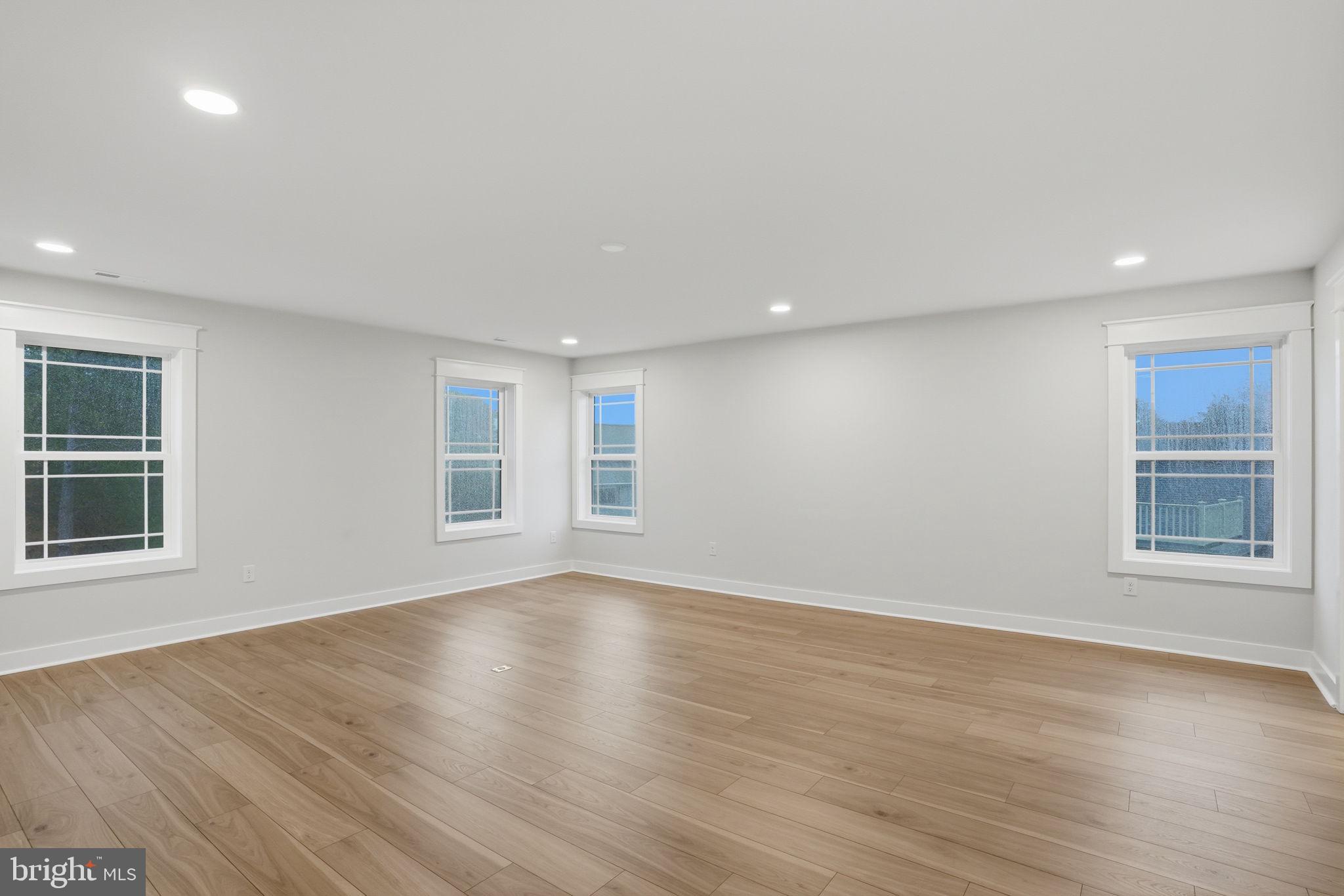 25015 Prairie Lane, Unit 3 Millsboro, DE 19966 - Photo 38 of 42 a view of an empty room with wooden floor and windows