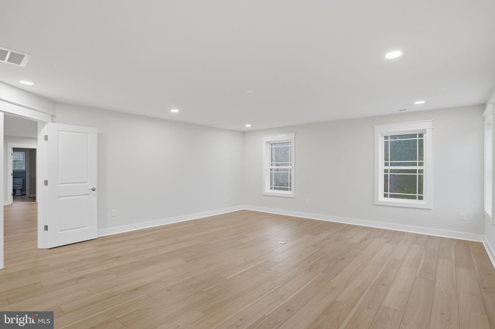 25015 Prairie Lane, Unit 3 Millsboro, DE 19966 - Photo 40 of 42 an empty room with wooden floor and windows