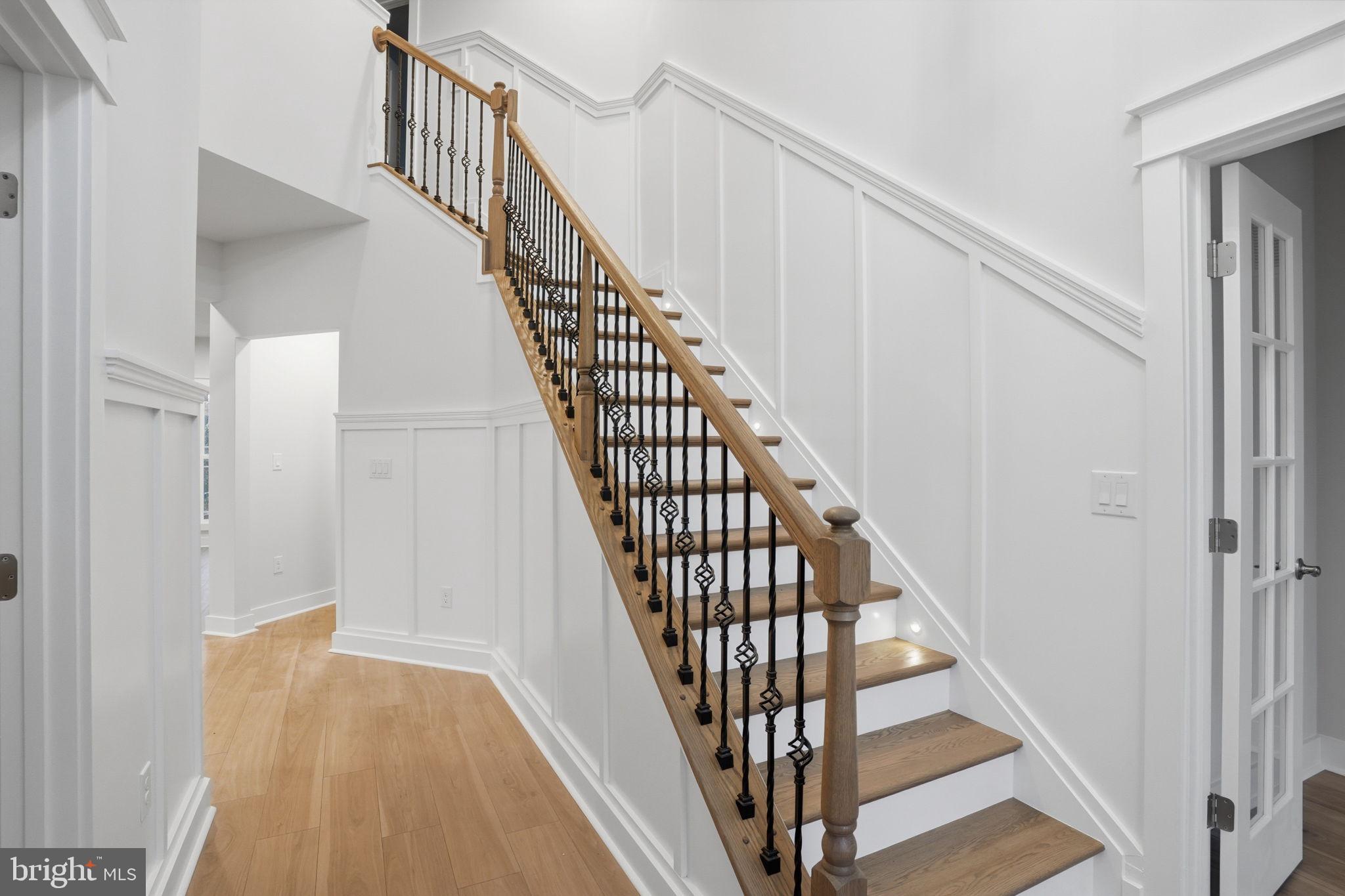 25015 Prairie Lane, Unit 3 Millsboro, DE 19966 - Photo 5 of 42 a view of staircase with wooden floor and white walls