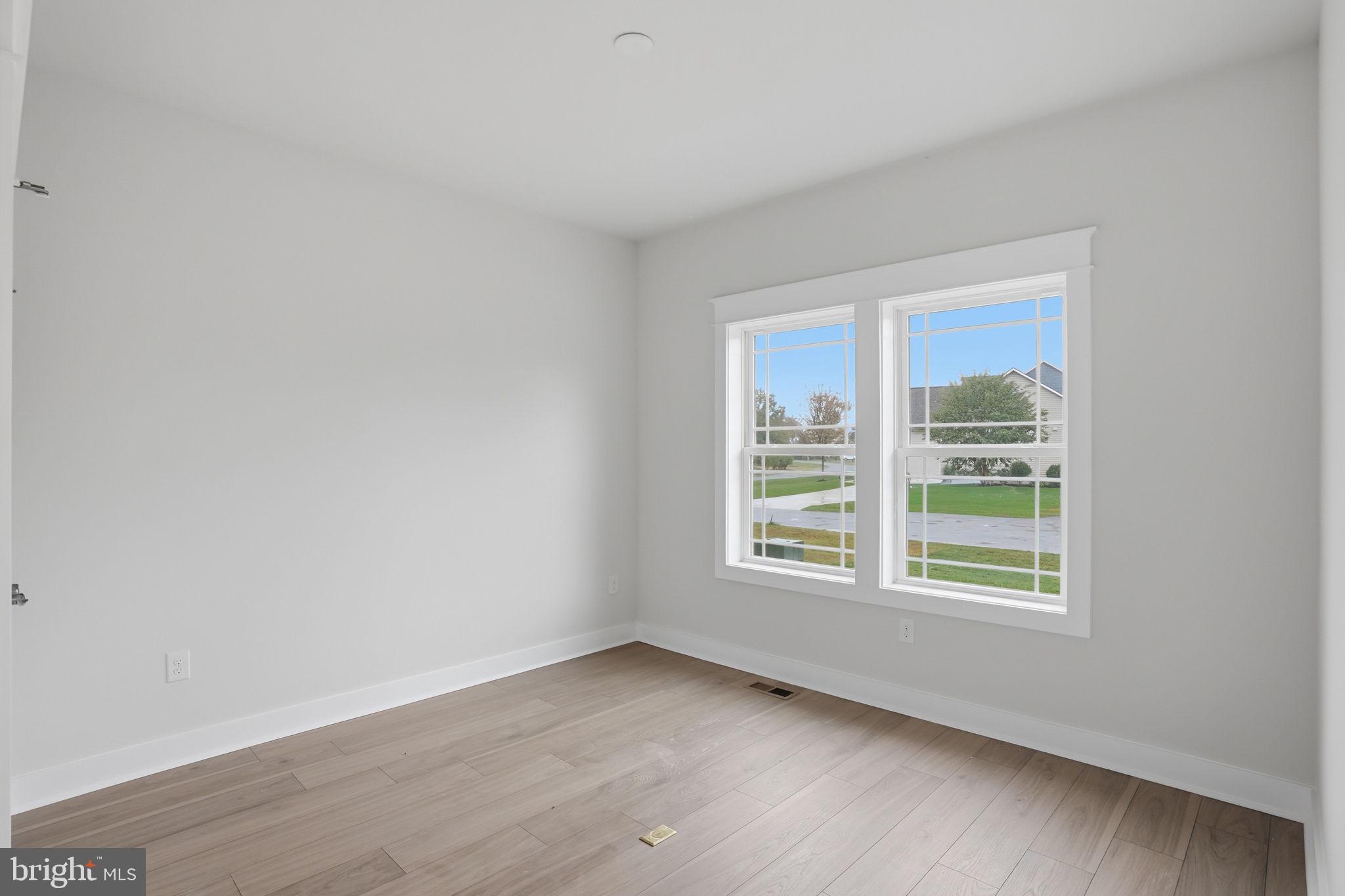 25015 Prairie Lane, Unit 3 Millsboro, DE 19966 - Photo 6 of 42 a view of an empty room with wooden floor and a window