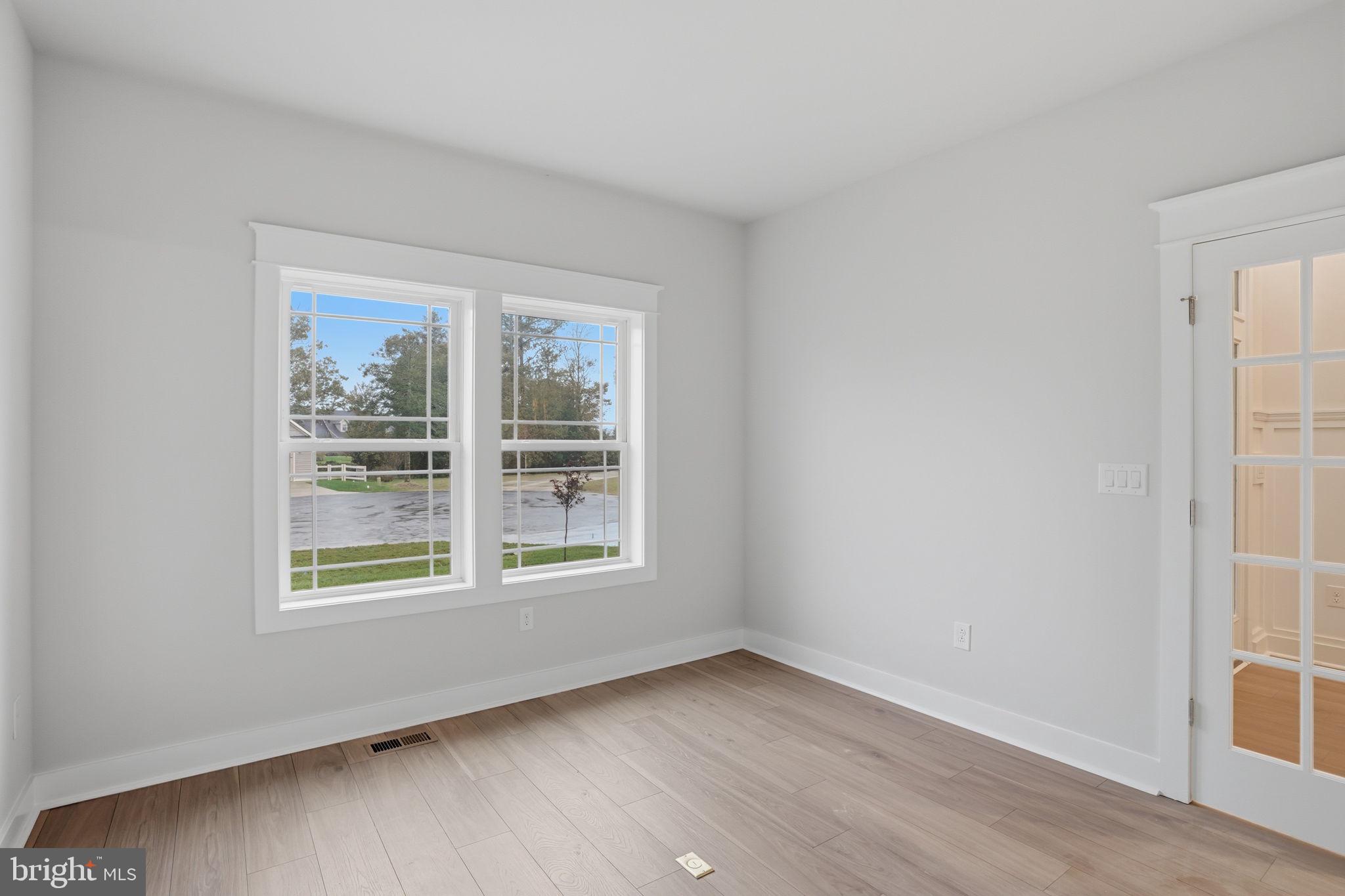 25015 Prairie Lane, Unit 3 Millsboro, DE 19966 - Photo 7 of 42 a view of an empty room with wooden floor and a window