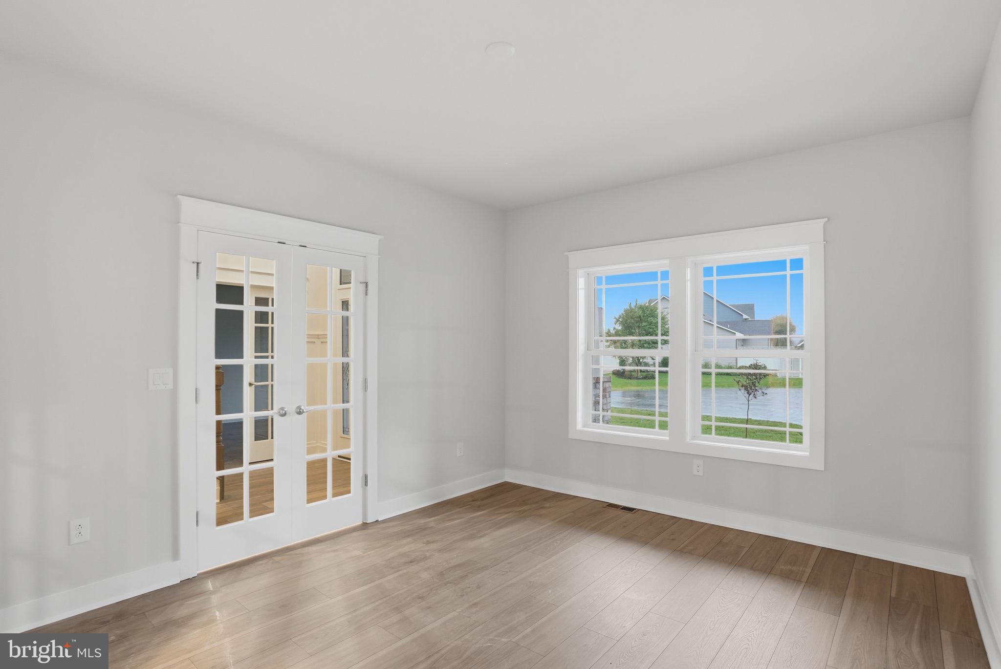 25015 Prairie Lane, Unit 3 Millsboro, DE 19966 - Photo 9 of 42 a view of an empty room with a window and wooden floor