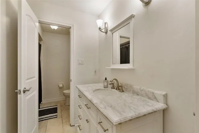 a bathroom with a granite countertop sink and a mirror
