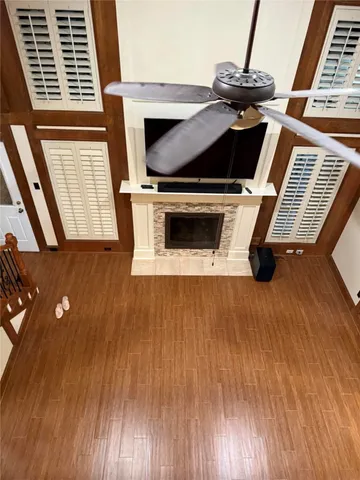 a view of an empty room with wooden floor and windows