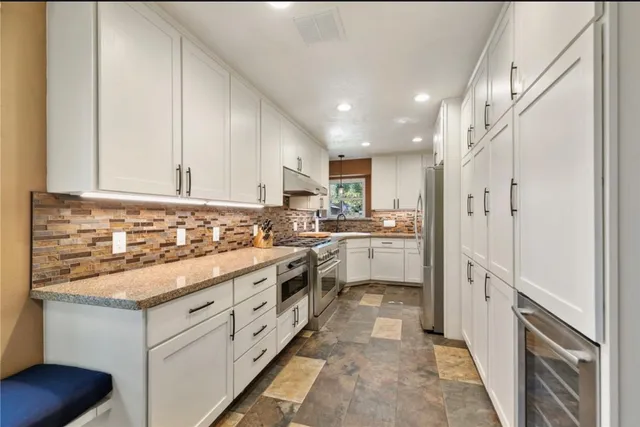 a kitchen with white cabinets and white appliances