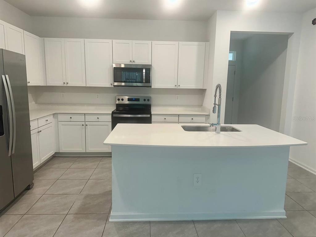 455 Redbud Road Palm Coast, FL 32137 - Photo 10 of 12 a kitchen with a sink a stove top oven and white kitchen
