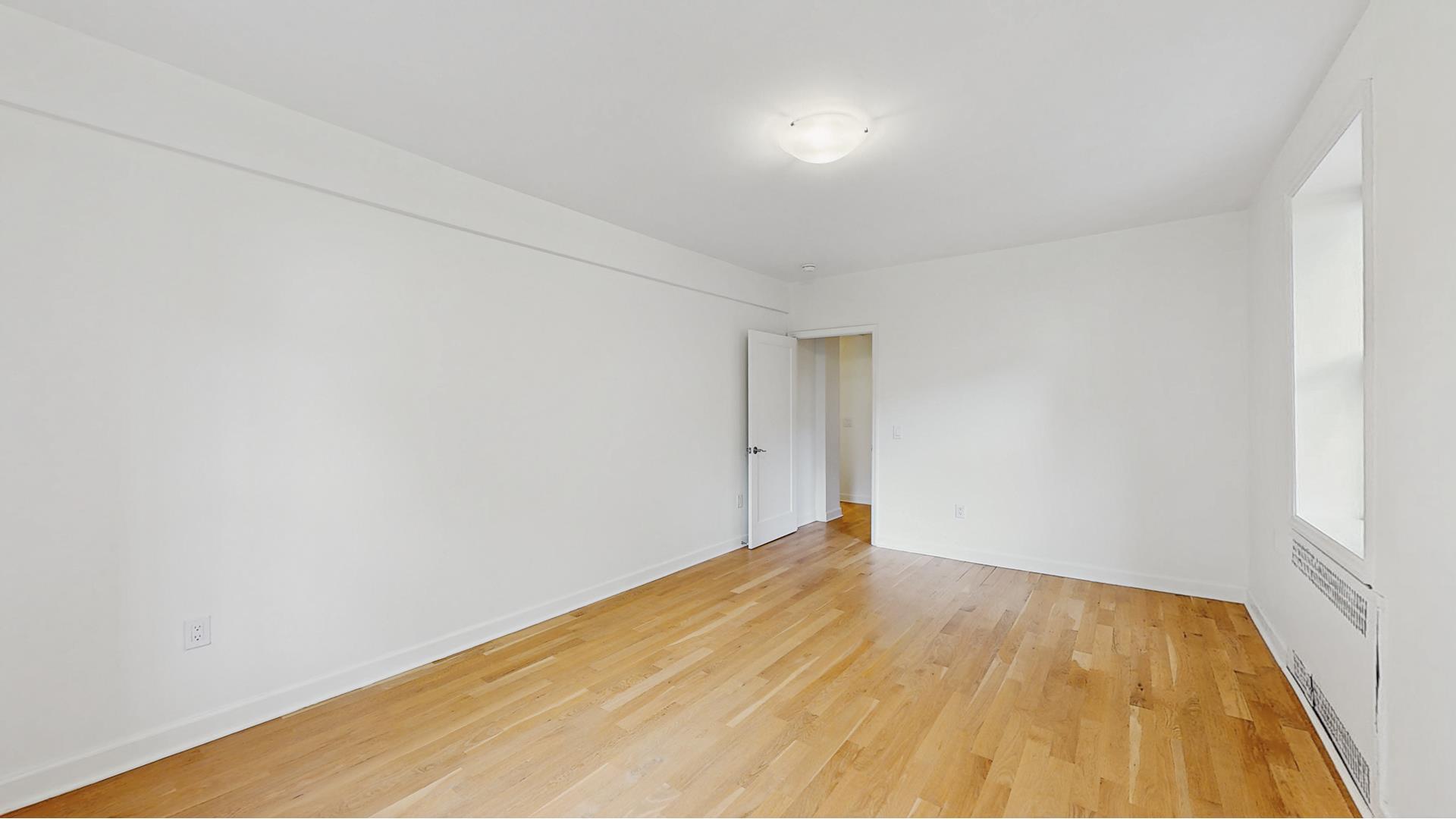 811 Cortelyou Road, Unit 1J Brooklyn, NY 11218 - Photo 9 of 15 a view of an empty room with wooden floor
