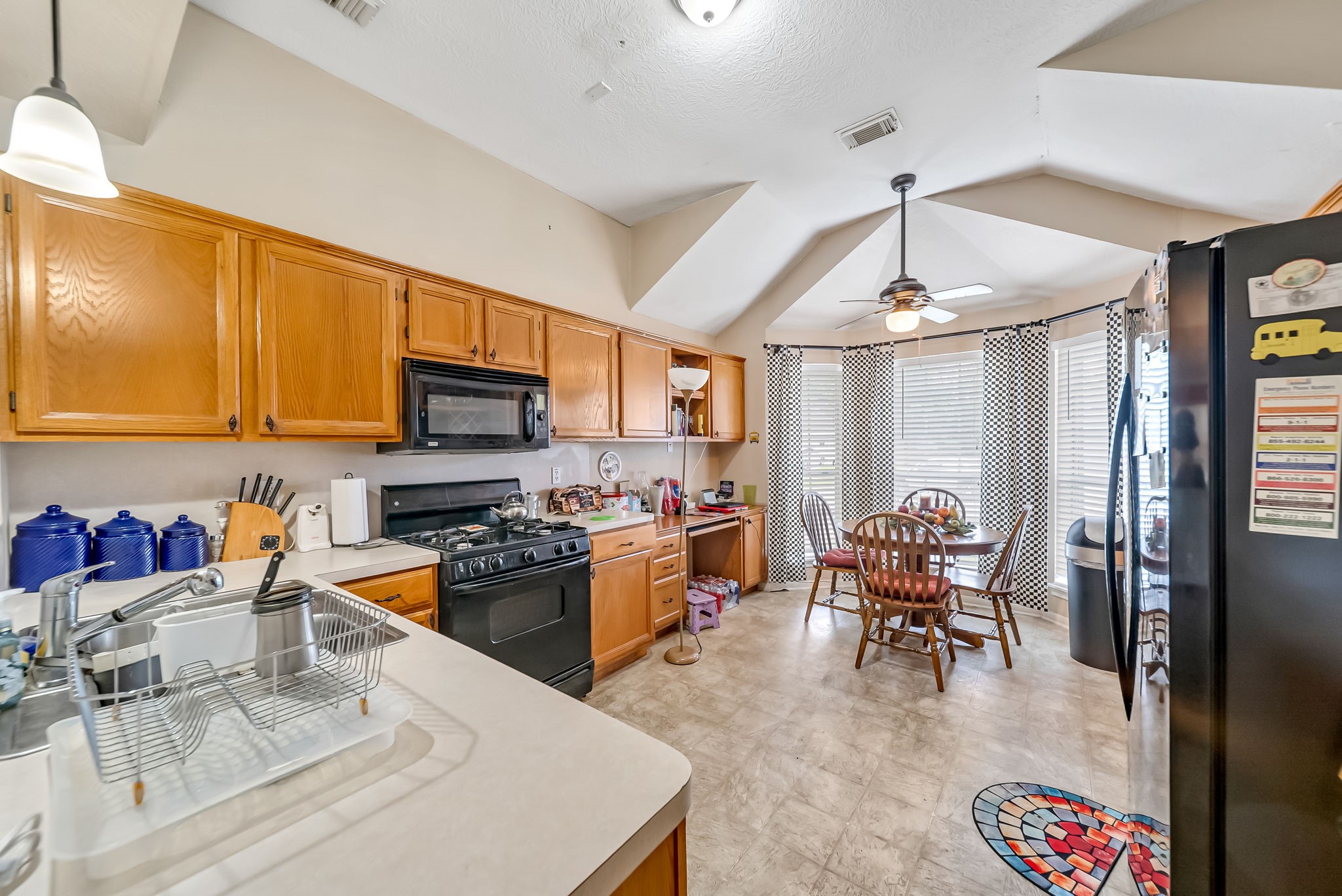 22906 Prairie Bird Lane Spring, TX 77373 - Photo 7 of 14 a kitchen with stainless steel appliances granite countertop a stove top oven a sink dishwasher and a dining table with cabinets