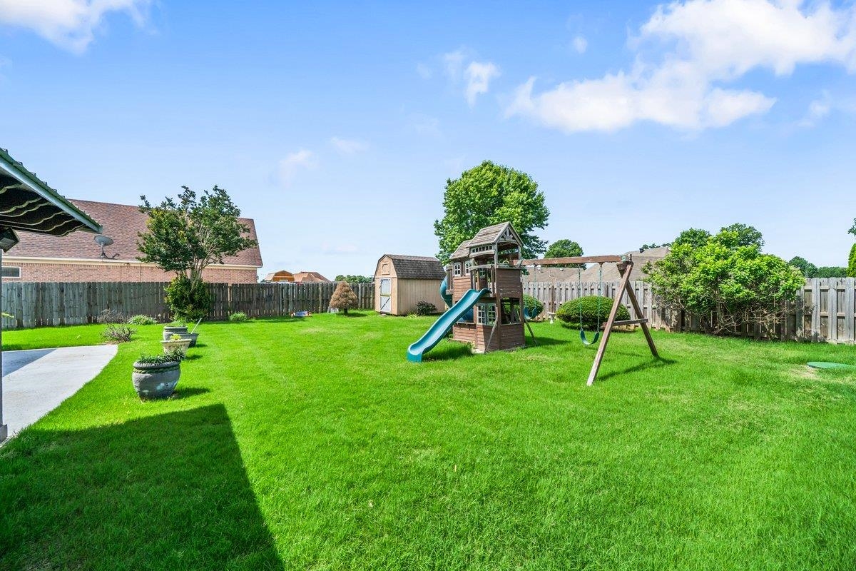 583 Rosemark Road Atoka, TN 38004 - Photo 24 of 25 a view of a backyard with a slide and a child swing