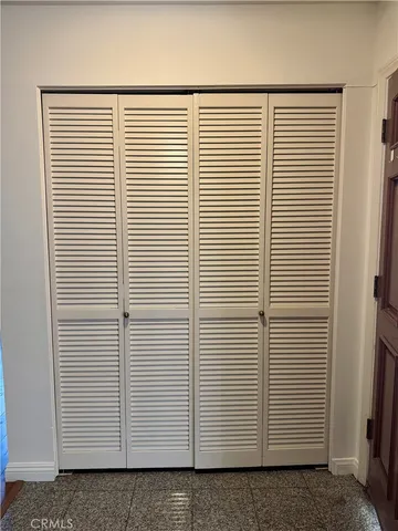 a view of an empty room with wooden floor fireplace and a window