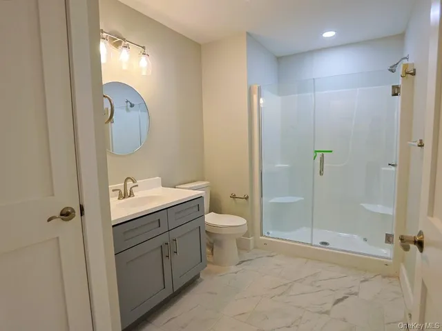 a bathroom with a granite countertop sink toilet and shower