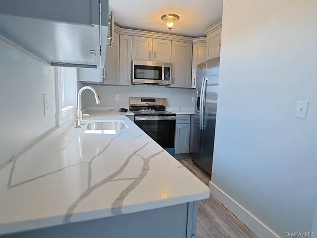 a kitchen with stainless steel appliances a refrigerator stove microwave and sink