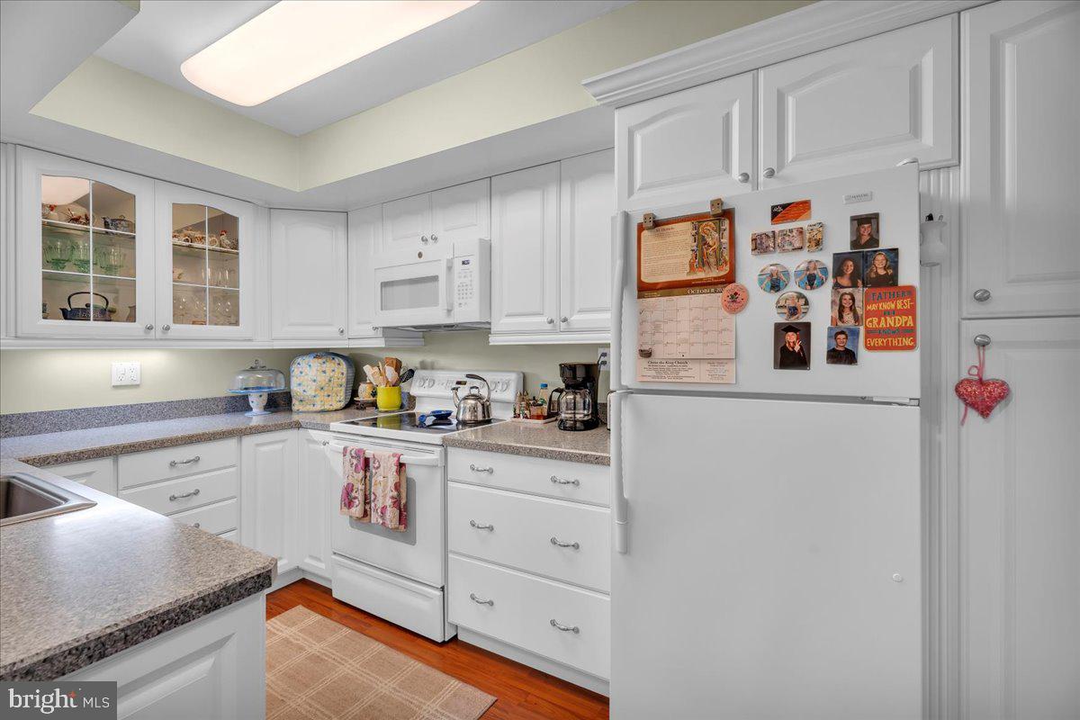 115 East Kings Highway, Unit 443 Maple Shade, NJ 08052 - Photo 13 of 24 a white kitchen with cabinets and wooden floor
