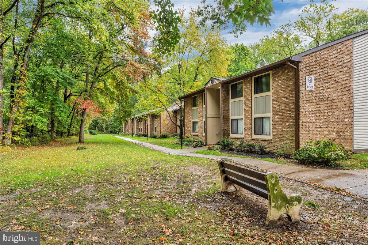 115 East Kings Highway, Unit 443 Maple Shade, NJ 08052 - Photo 2 of 24 a white bench sitting in front of a house with a yard