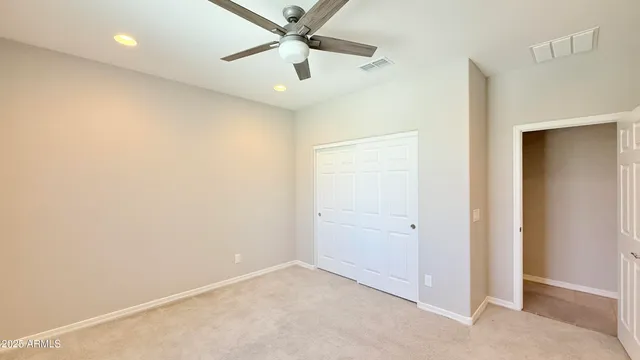 an empty room with closet and fan