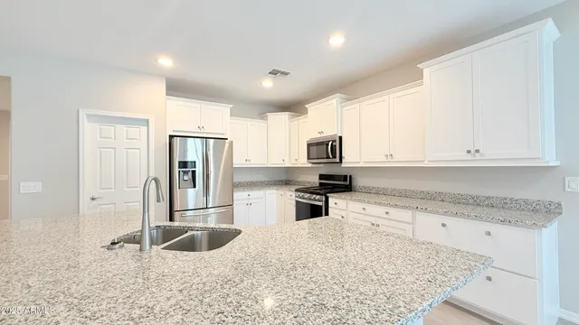 a kitchen with stainless steel appliances granite countertop a refrigerator and a sink