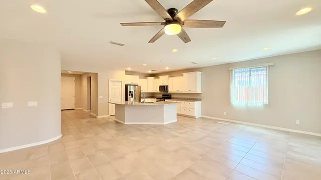 a view of kitchen with stainless steel appliances cabinets and living room view